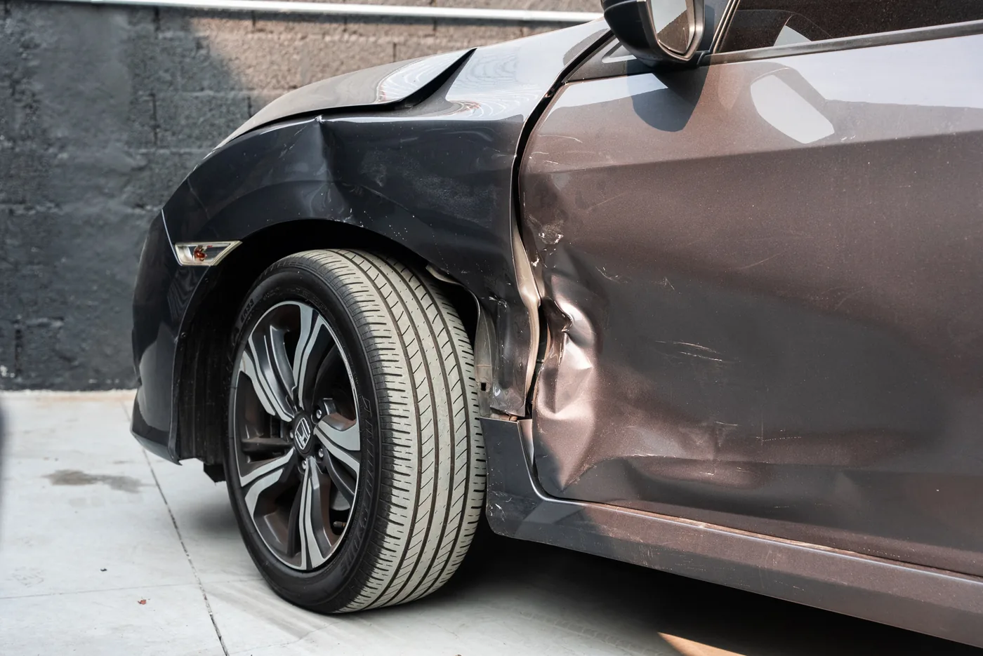 Carro com paralama e porta amassados após uma colisão lateral